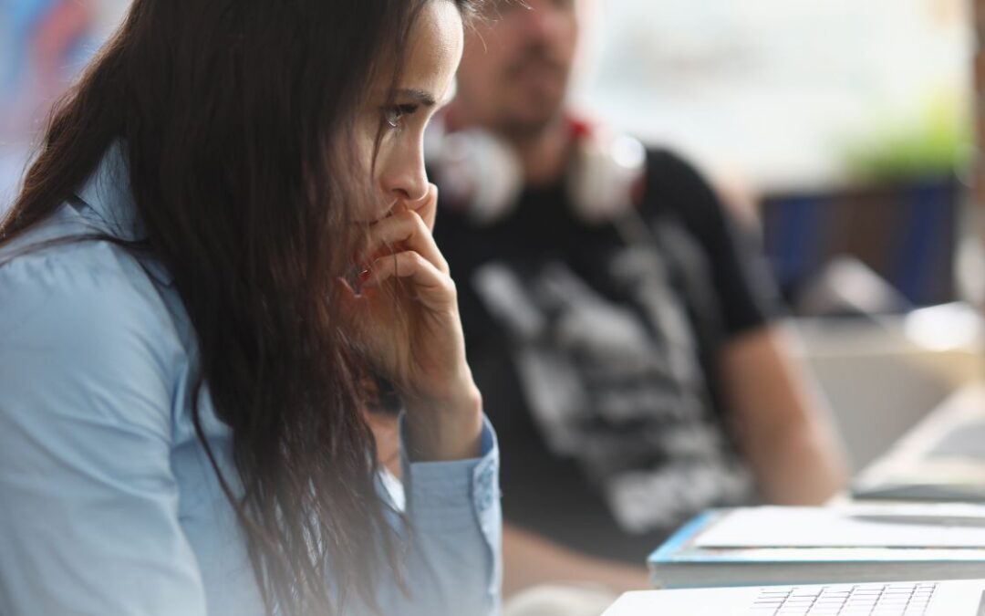 AST Cybersecurity woman nervously looking at her computer during a meeting